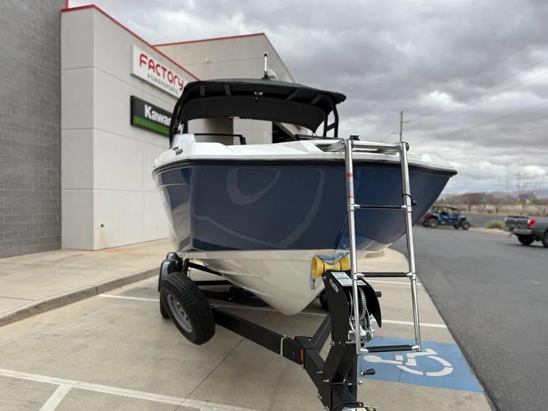 Slide: The Image of 2025 Yamaha Boats AR220 on trailer outside dealership, cloudy sky background. - 16