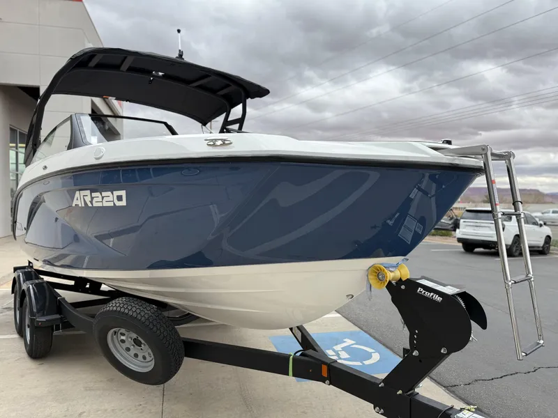 Slide: The Image of 2025 Yamaha Boats AR220 on trailer, parked outdoors under cloudy sky. - 17