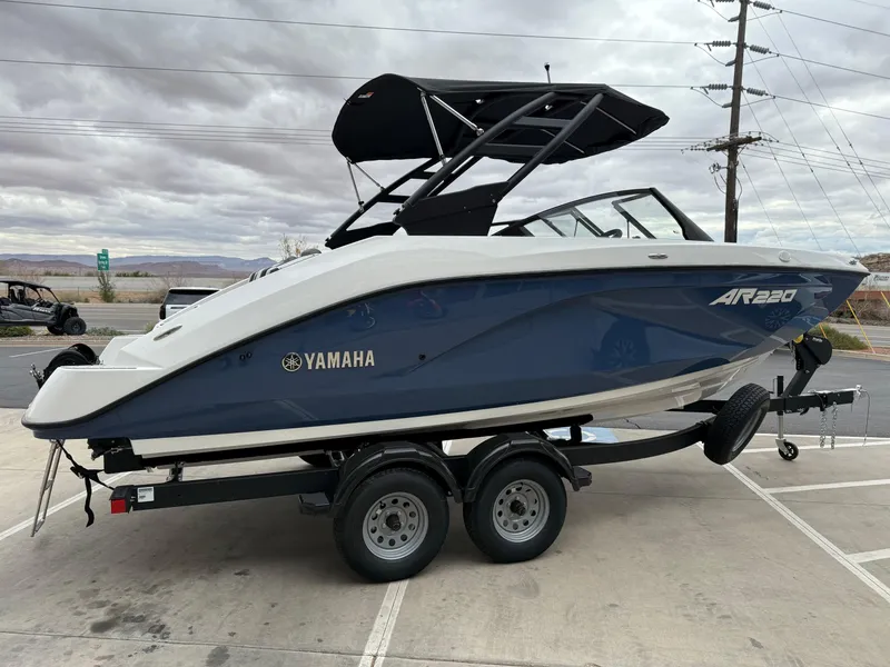 Slide: The Image of 2025 Yamaha Boats AR220 on trailer, sleek design, blue and white color scheme, overcast sky. - 4