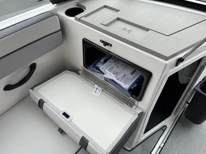 Slide: The Image of 2025 Yamaha Boats AR220 interior storage compartment with open hatch and visible contents. - 43