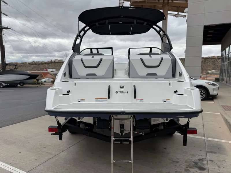 Slide: The Image of 2025 Yamaha Boats AR220, rear view, white exterior, parked outdoors. - 7