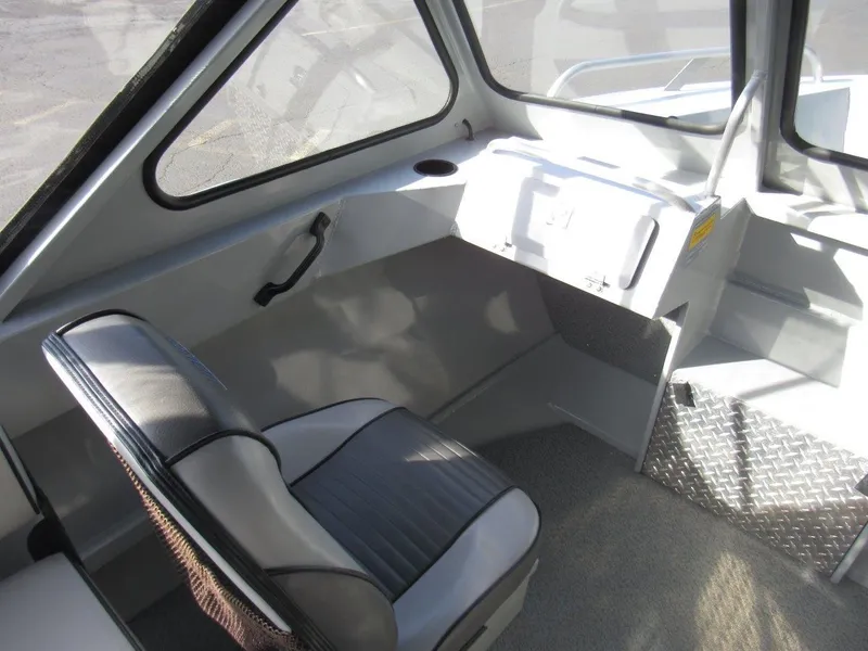 Slide: The Image of Interior of 2015 Hewescraft 180 Sportsman boat, featuring seating and dashboard area. - 13