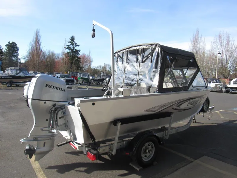 Slide: The Image of 2015 Hewescraft 180 Sportsman boat with Honda outboard motor in a parking lot. - 5