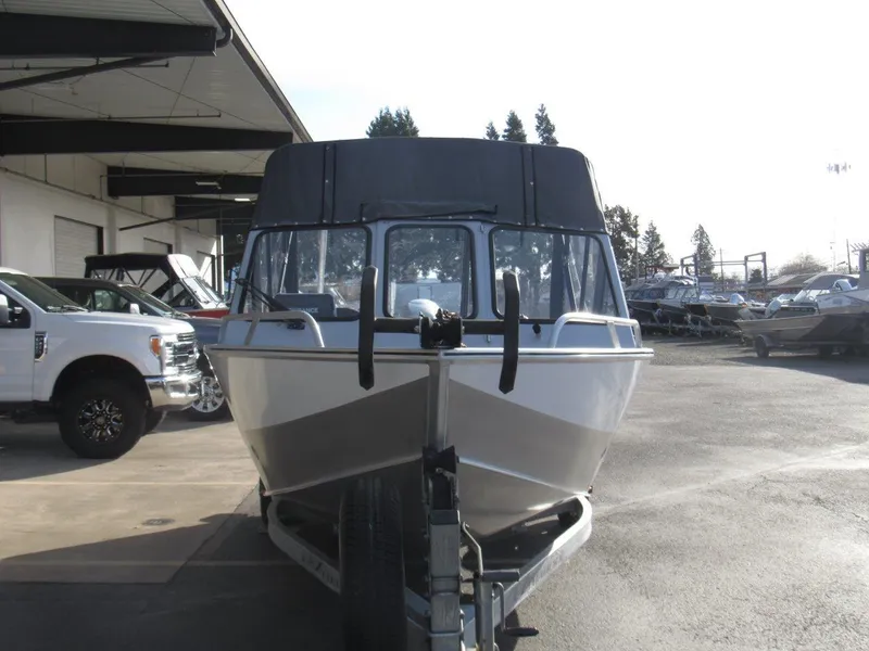 Slide: The Image of 2015 Hewescraft 180 Sportsman boat on trailer, parked outdoors near vehicles. - 8