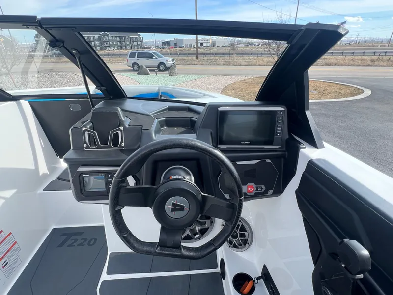 Slide: The Image of 2023 Axis Wake Research T220 boat dashboard with steering wheel and navigation display. - 15