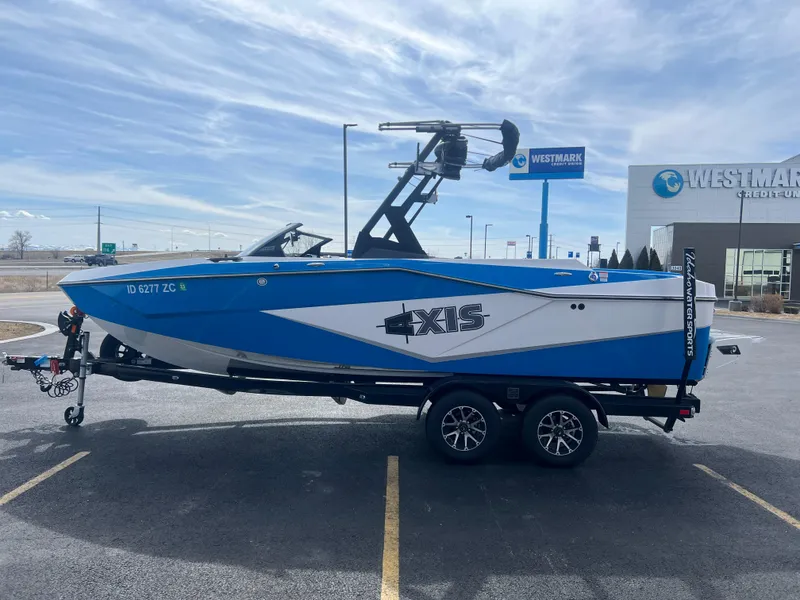 Slide: The Image of 2023 Axis Wake Research T220 boat on trailer, parked in a lot near Westmark Credit Union. - 6