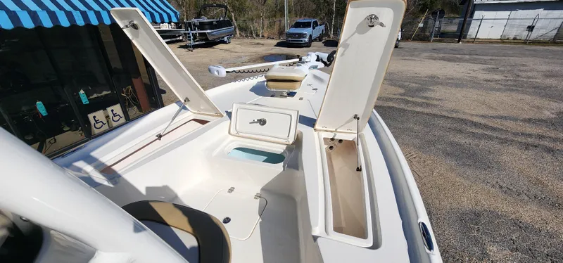 Slide: The Image of 2019 Key West 230BR boat with open storage compartments, parked outdoors. - 15
