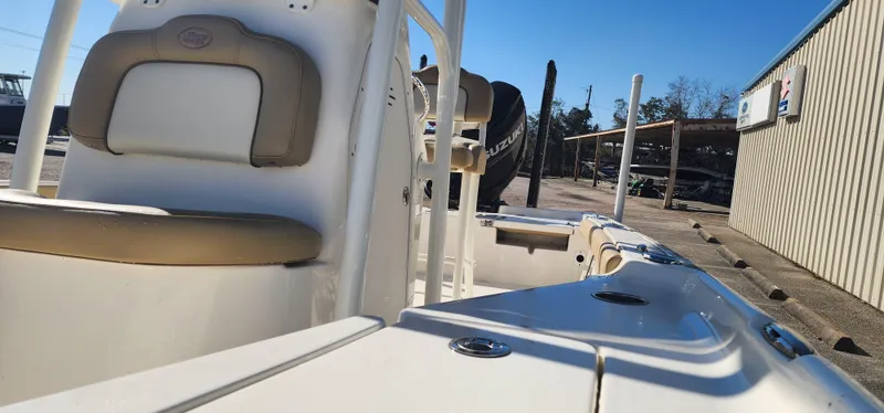 Slide: The Image of 2019 Key West 230BR boat interior with seating and console, docked under clear blue sky. - 7