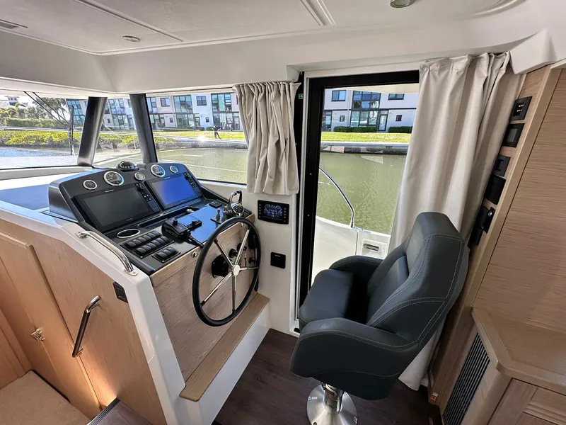 Slide: The Image of 2023 Beneteau Swift Trawler 48 helm station with modern controls and comfortable seating. - 13