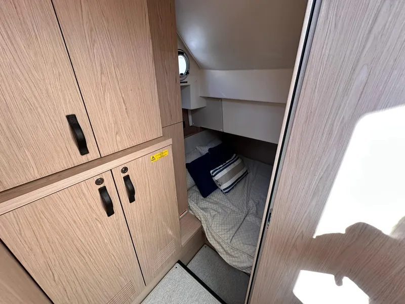 Slide: The Image of 2023 Beneteau Swift Trawler 48 cabin interior with wood finish and cozy bedding. - 19