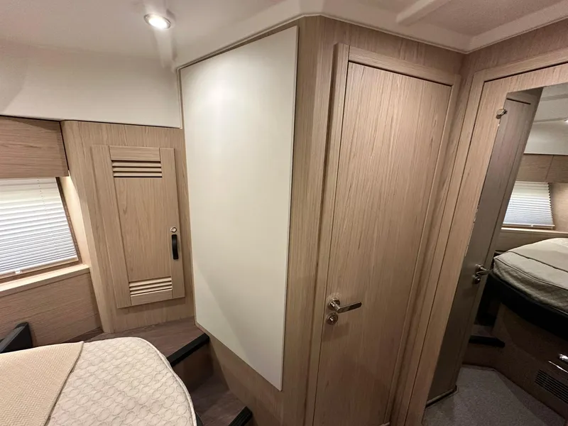 Slide: The Image of 2023 Beneteau Swift Trawler 48 interior cabin with modern wood finish and cozy design. - 23