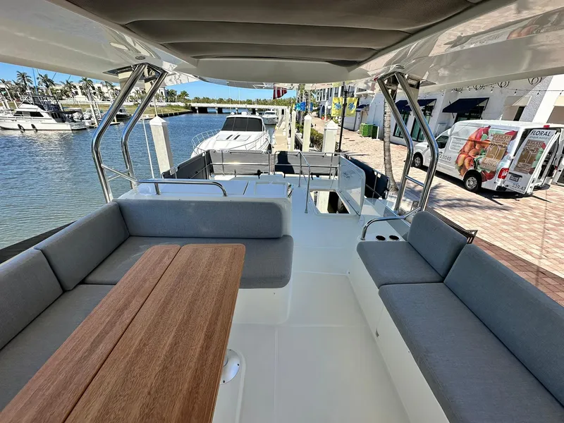 Slide: The Image of 2023 Beneteau Swift Trawler 48, spacious deck with seating, docked at marina. - 31