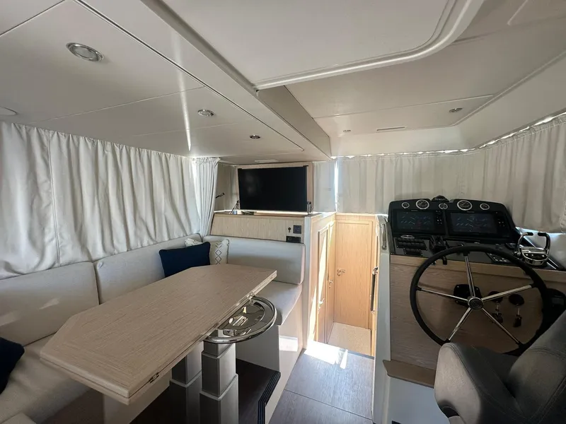 Slide: The Image of 2023 Beneteau Swift Trawler 48 interior with helm, dining area, and modern furnishings. - 34