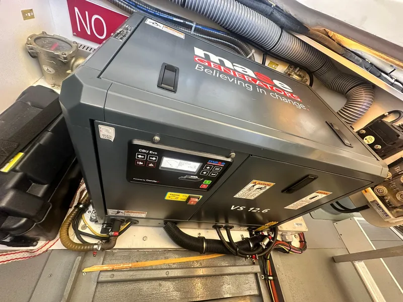 Slide: The Image of 2023 Beneteau Swift Trawler 48 engine room with generator and wiring. - 37