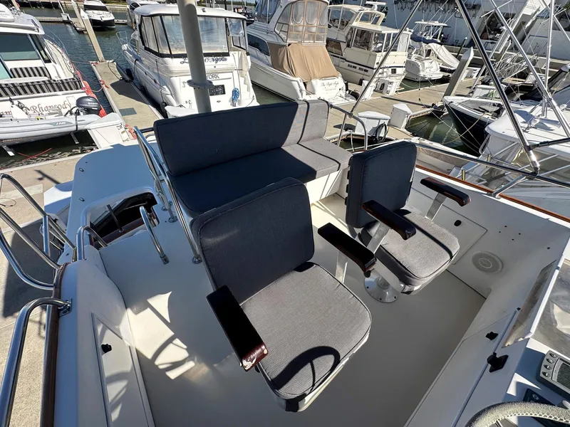 Slide: The Image of 2000 Legacy Yachts 40 Sedan boat interior with cushioned seating at marina. - 15