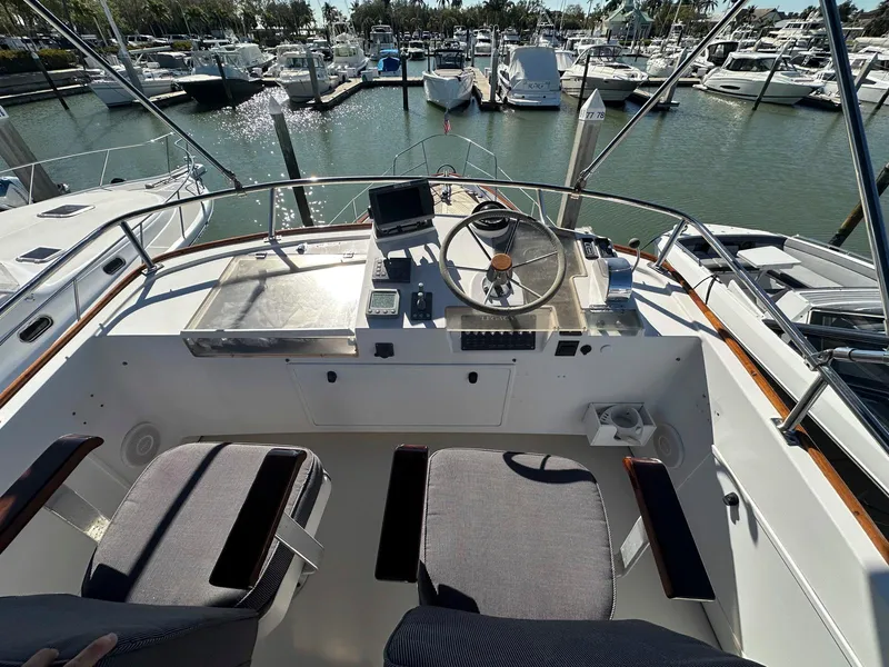 Slide: The Image of Cockpit view of 2000 Legacy Yachts 40 Sedan at marina, featuring helm and seating. - 16