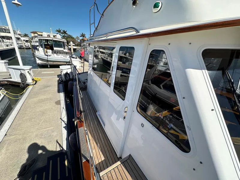 Slide: The Image of 2000 Legacy Yachts 40 Sedan docked at marina, side view with clear skies. - 20