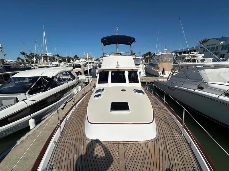 Slide: The Image of 2000 Legacy Yachts 40 Sedan docked among other boats in a marina. - 22