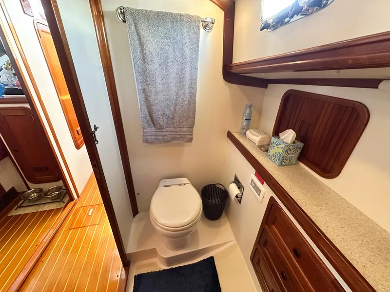 Slide: The Image of Compact kitchen in 2000 Legacy 40 Sedan boat with sink, countertop, and wooden cabinets. - 38