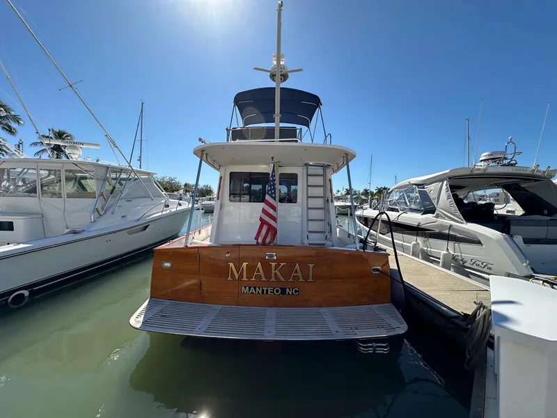 Slide: The Image of Legacy Yachts 40 Sedan 2000 docked, rear view with American flag, sunny day. - 7
