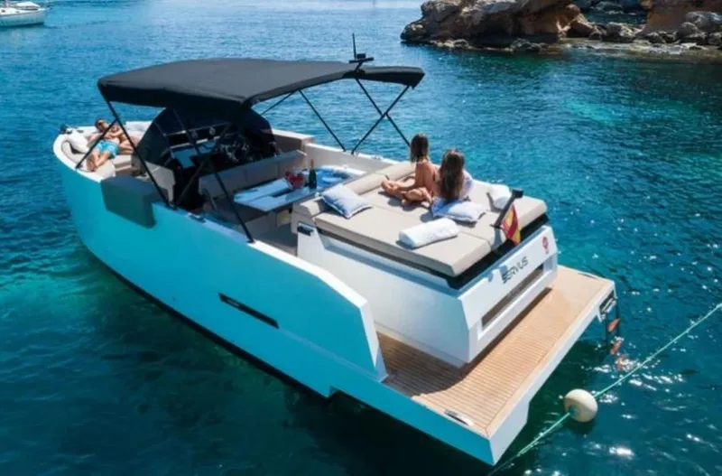 Slide: The Image of 2024 De Antonio Yachts D28 Open cruising in clear blue waters, featuring sunbathing area and sleek design. - 1