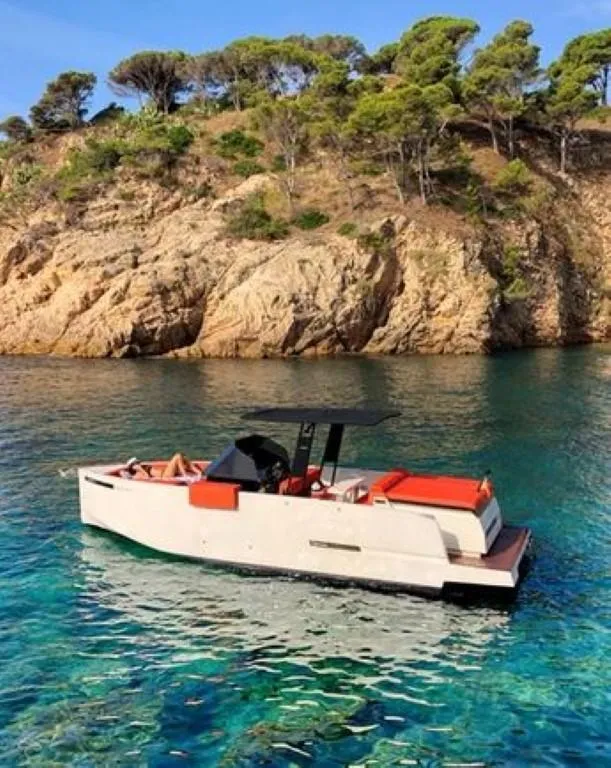 Slide: The Image of 2024 De Antonio Yachts D28 Open in clear blue water near rocky coastline. - 7