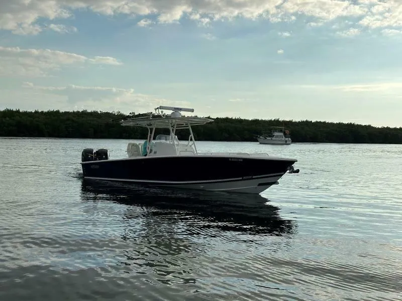 The Image of 2008 Jupiter 31 FS Center Console boat on calm water, with trees in the background. - 1