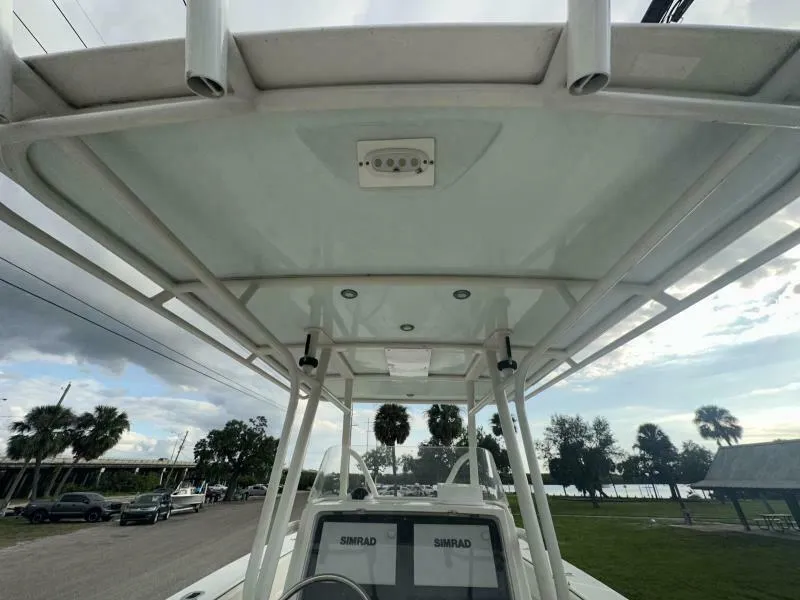 Slide: The Image of 2008 Jupiter 31 FS Center Console boat with T-top and electronics, parked near palm trees. - 10