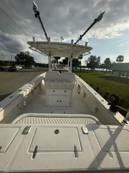 Slide: The Image of 2008 Jupiter 31 FS Center Console boat with spacious deck and fishing rods, docked under cloudy skies. - 7
