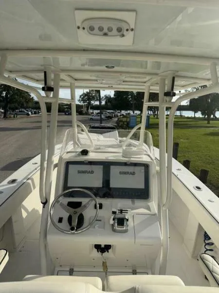 Slide: The Image of 2008 Jupiter 31 FS Center Console boat with dual Simrad displays, docked near a park. - 9