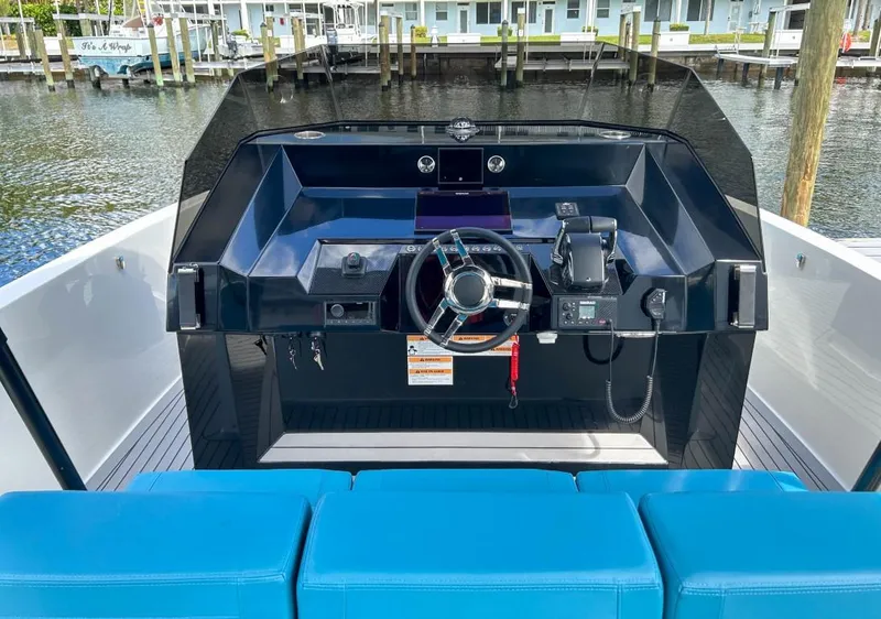 Slide: The Image of 2023 De Antonio Yachts D28 Open dashboard with blue seating, dockside view. - 12