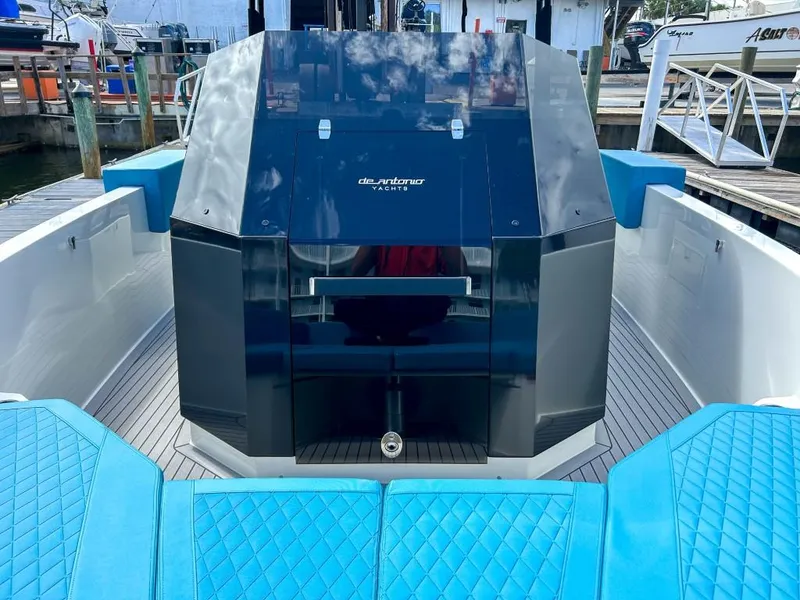 Slide: The Image of 2023 De Antonio Yachts D28 Open with sleek design and blue seating at a marina. - 22