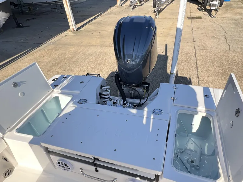 Slide: The Image of 2024 Robalo 246 Cayman boat with open storage compartments and outboard motor. - 11