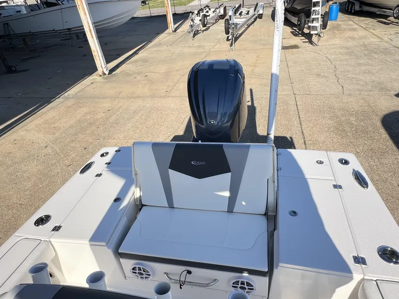 Slide: The Image of 2024 Robalo 246 Cayman boat interior with seating and motor, docked outdoors. - 13