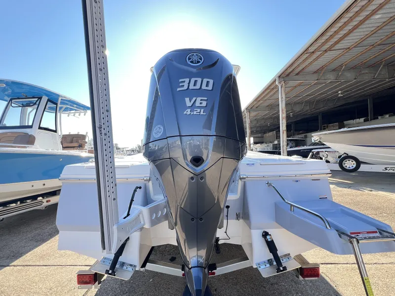 Slide: The Image of 2024 Robalo 246 Cayman with Yamaha 300 V6 engine, displayed in a boatyard. - 15