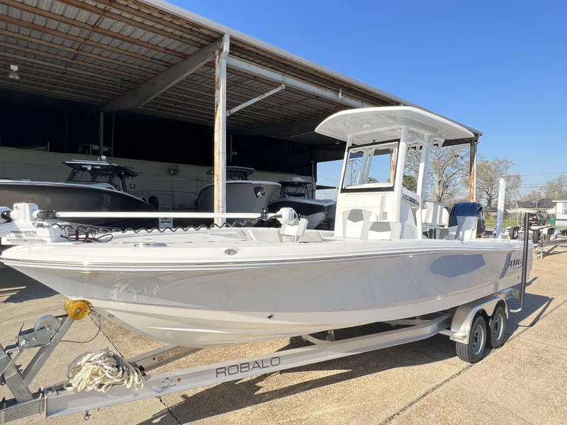 Slide: The Image of 2024 Robalo 246 Cayman boat on trailer under a metal canopy, sunny day. - 3