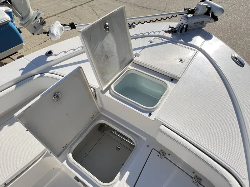 Slide: The Image of 2024 Robalo 246 Cayman boat with open storage compartments and trolling motor. - 4