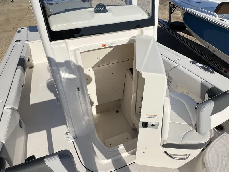 Slide: The Image of 2024 Robalo 246 Cayman boat interior with open storage compartment and seating. - 6