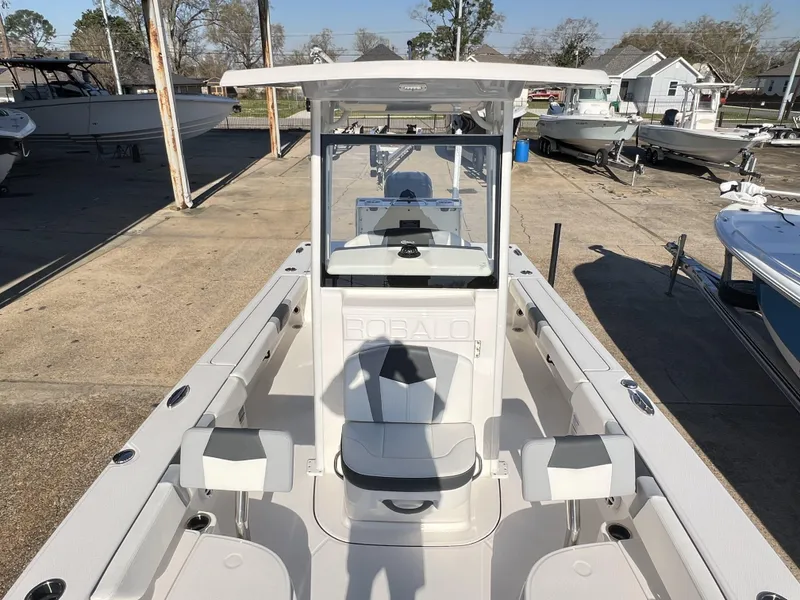 Slide: The Image of 2024 Robalo 246 Cayman boat, white interior, docked at a marina under clear skies. - 7