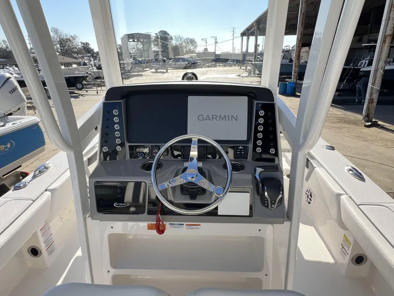 Slide: The Image of 2024 Robalo 246 Cayman boat helm with Garmin display and steering wheel. - 9