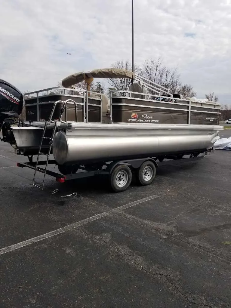 Slide: The Image of 2025 Sun Tracker SportFish 20 DLX pontoon boat on trailer in parking lot. - 3