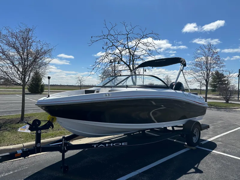 Slide: The Image of 2024 Tahoe 185 S boat on trailer in parking lot under clear blue sky. - 0