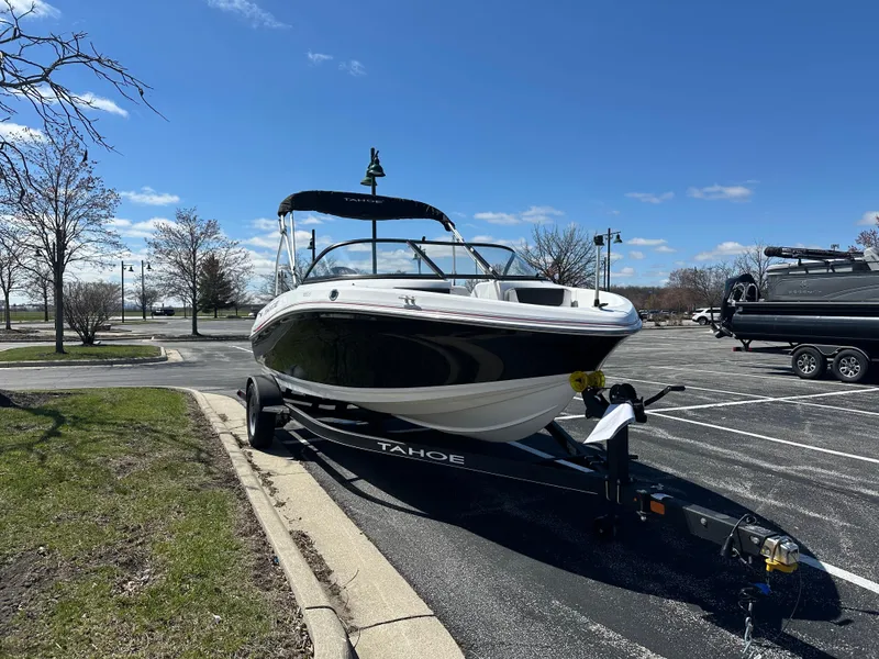 Slide: The Image of 2024 Tahoe 185 S boat on trailer in parking lot under clear blue sky. - 1