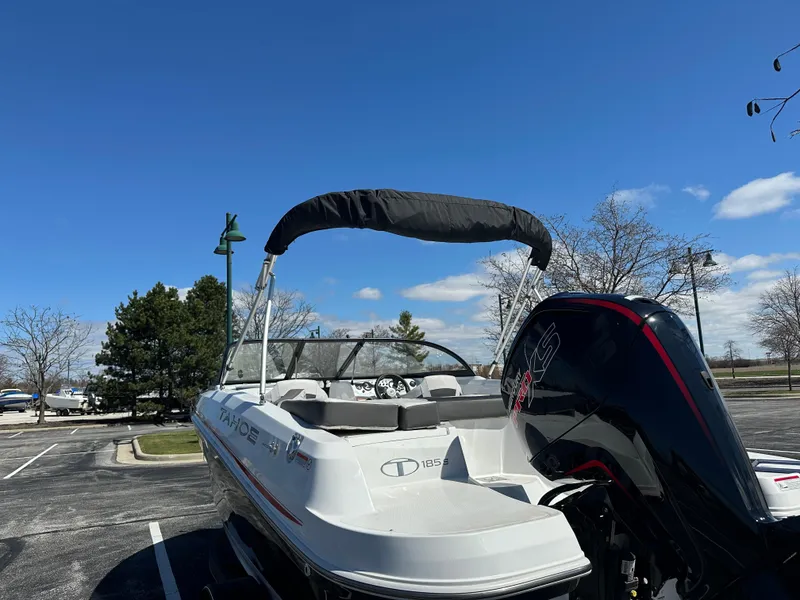 Slide: The Image of 2024 Tahoe 185 S boat with canopy, parked outdoors under a clear blue sky. - 5