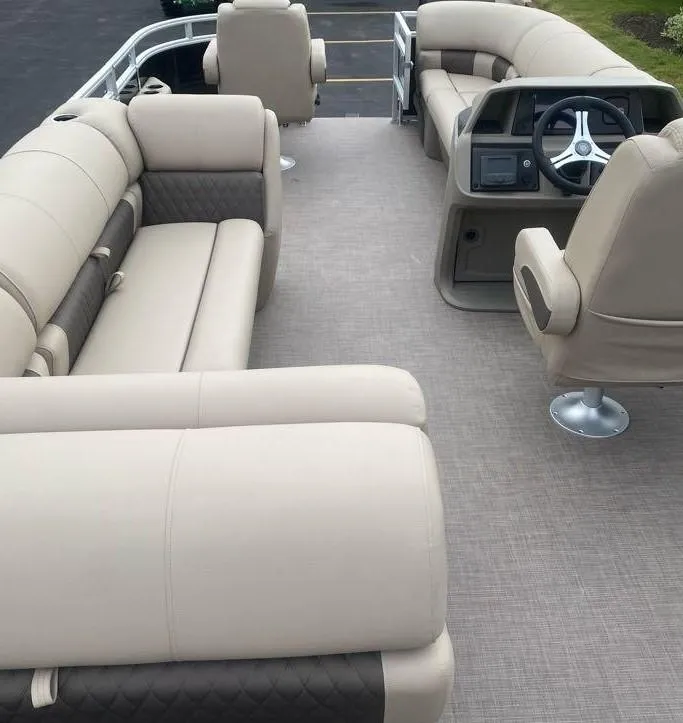 Slide: The Image of 2024 Sun Tracker SportFish 20 DLX pontoon boat interior with beige seating and steering console. - 5