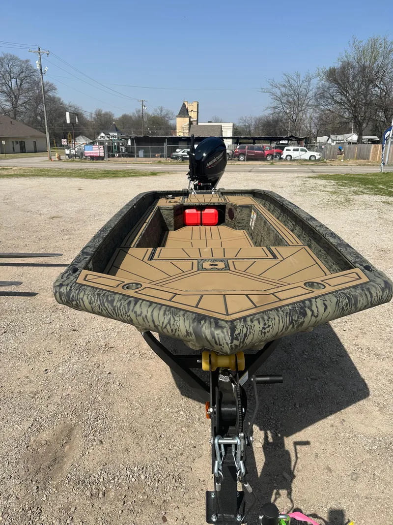 Slide: The Image of 2025 Tracker Grizzly 1650 T Prairie Wings Edition boat on trailer, parked outdoors. - 10