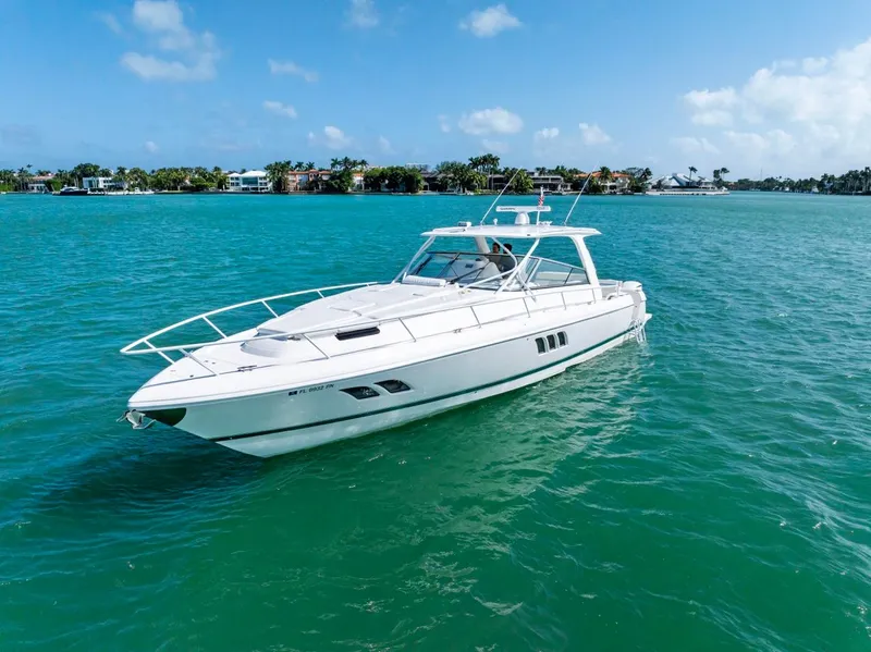 The Image of 2018 Intrepid 475 Sport Yacht cruising on turquoise waters under a clear blue sky. - 1