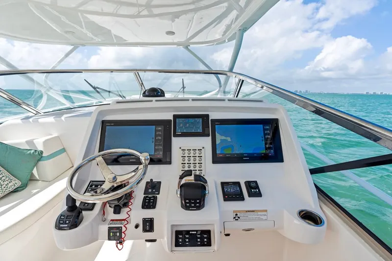Slide: The Image of 2018 Intrepid 475 Sport Yacht helm with navigation screens and ocean view. - 12