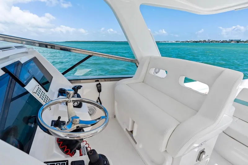 Slide: The Image of 2018 Intrepid 475 Sport Yacht helm with ocean view, featuring sleek design and modern controls. - 14