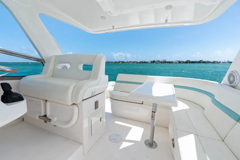 Slide: The Image of 2018 Intrepid 475 Sport Yacht interior with white seating and ocean view. - 16